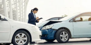 An insurance adjuster inspects a car to file an auto insurance claim.